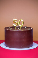 Homemade chocolate cake with two candles, birthday - fifty years anniversary