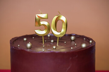 Homemade chocolate cake with two candles, birthday - fifty years anniversary