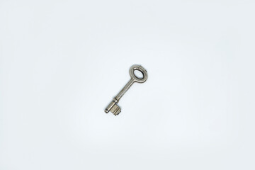 Photo of a house key made of chrome plated metal isolated in white background