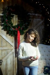 Baby girl in festive attire is in the room decorated for the new year and Christmas.