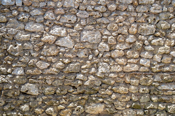 An old rubble stone wall full frame background close up