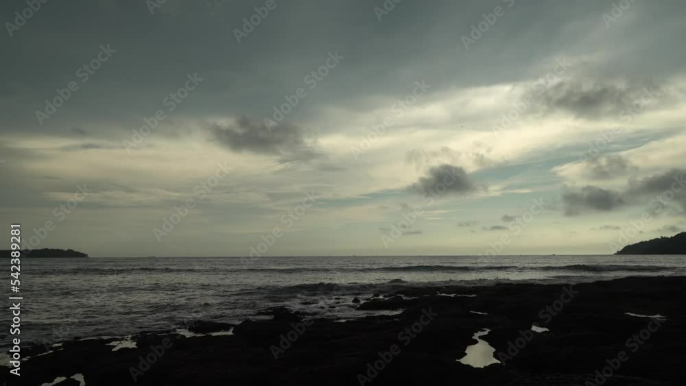 Poster Timelapse static shot of a lake with calm waters and small waves on the shore while the clouds pass by on a sunrise in the early morning