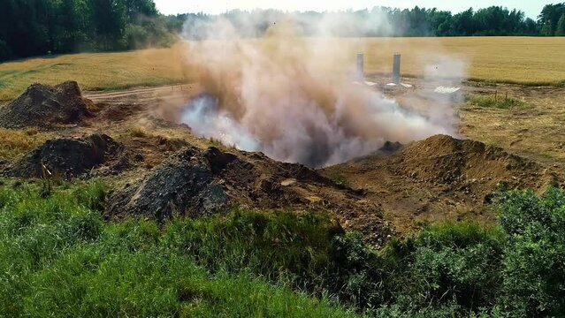 Shot of an dynamite explosion in a rock quarry in rural countryside on a bright sunny day.