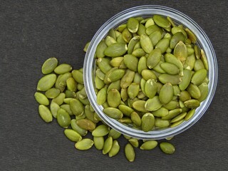 Green pumpkin seeds in a bowl top view 