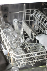 Clean washed dishes lying in the dishwasher. Concept of cleanliness and organization of order in the house