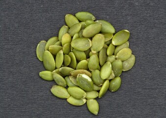 Green pumpkin seeds on black background 