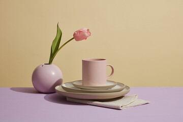 Front view of stacked dishes, cups, and flower vases. Pastel color ceramic kitchenware. Kitchen decoration.