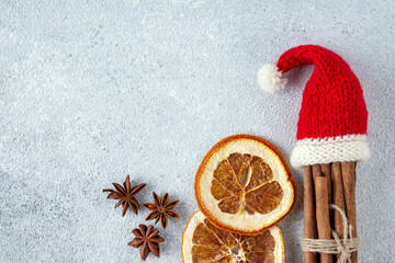 mulled wine set - cinnamon sticks in santa hat, cloves, dried oranges, copy space