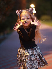 The little girl plays in the park in the fall