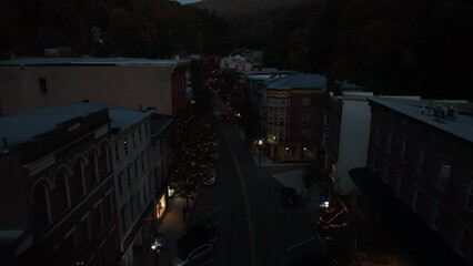 Christmas lights on outdoor trees in USA town. Aerial flight in evening darkness. Christmas Eve theme. Santa sleigh and reindeer flying over chimneys effect. - Powered by Adobe