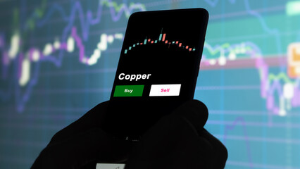 An investor's analyzing the Copper etf fund on screen. A phone shows the ETF's prices copper to invest