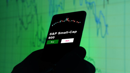 An investor's analyzing the S&P Small-Cap 600 etf fund on screen. A phone shows the ETF's prices stocks to invest