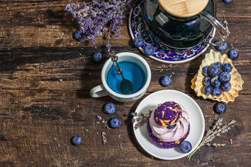 Obraz na płótnie Canvas The concept of romantic tea. French Shu cake, Lavender tea, blueberries, festive decor