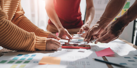 Obraz premium UI UX creative designer team designing wireframe layout for responsive mobile smartphone application in office