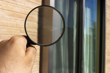  住宅の窓サッシを虫メガネで点検するイメージ