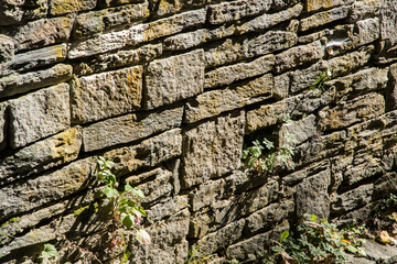 Old solid stone wall closeup in sunny day