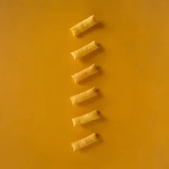 Wandcirkels aluminium Row of crunchy cookies on a yellow background © Adana Eisagholian/Wirestock Creators