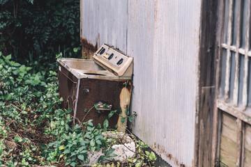廃墟の荒れ果てた古い洗濯機
