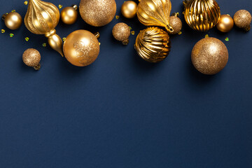 Christmas banner with golden glitter balls and toys on blue background with copy space