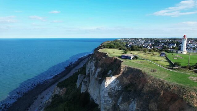 Drone flying over high chalky cliffs near La H&egrave;ve lighthouse, Sainte-Adresse city, France. Aerial forward. Sky for copy space
