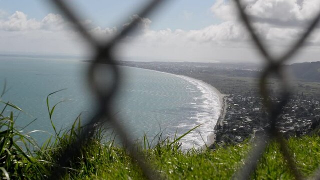 Spectacular ocean view behind blurry chain-link fence in foreground