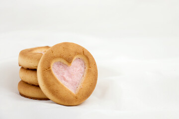 Sponge cookies with a heart and a white mug. Background for lovers on Valentine's Day