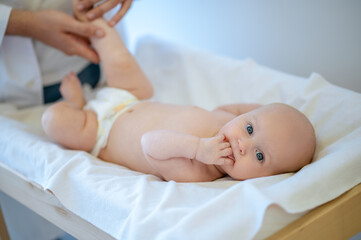 Surgeon checking babys limbs and moving them