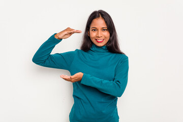 Young Indian woman isolated on white background holding something little with forefingers, smiling and confident.