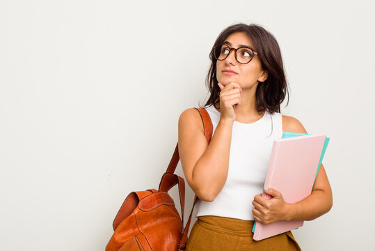 Young student Indian woman isolated on white background looking sideways with doubtful and skeptical expression.