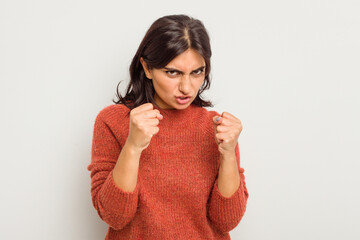 Young Indian woman isolated on white background showing fist to camera, aggressive facial...