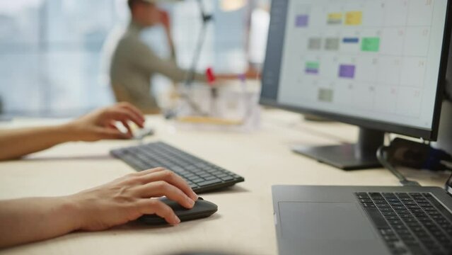 Close Up Footage of Woman's Hands Working on Keyboard and Monitor. Young Woman's hands Moving the Computer Mouse and Typing. Female Sales Manager Developing a Time Management Plan. Dolly Shot.