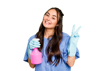 Young cleaner caucasian woman isolated on green chroma background joyful and carefree showing a...