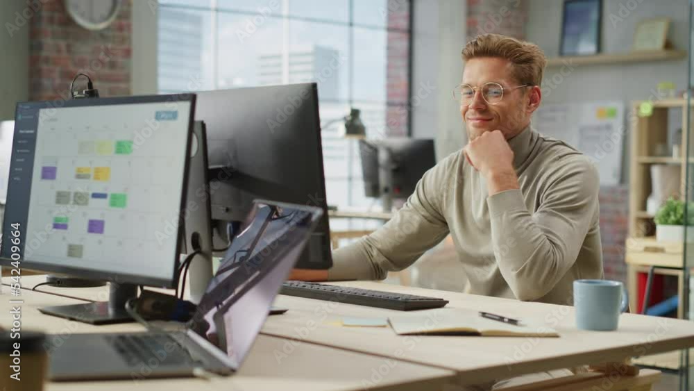 Poster portrait of enthousiastic caucasian young male working on computer in a modern bright office. confid