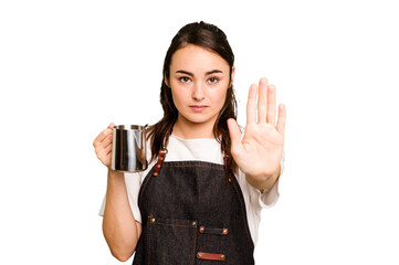 Young barista woman isolated on green chroma background standing with outstretched hand showing...