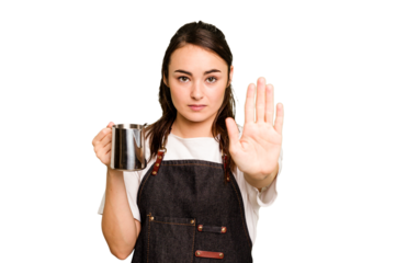 Young barista woman isolated on green chroma background standing with outstretched hand showing stop sign, preventing you.