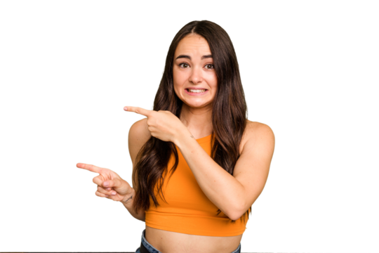 Young caucasian woman isolated on green chroma background shocked pointing with index fingers to a copy space.
