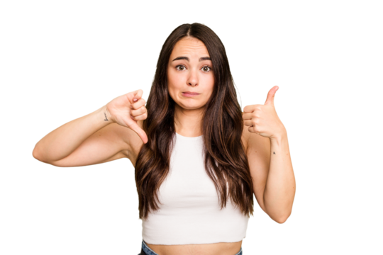 Young caucasian woman isolated on green chroma background showing thumbs up and thumbs down, difficult choose concept