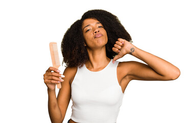 Young african american woman holding hair comb isolated feels proud and self confident, example to...