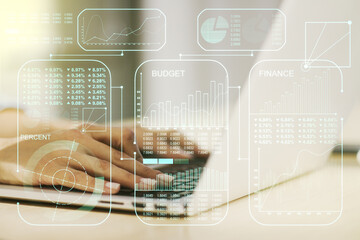 Double exposure of abstract creative statistics data hologram with hands typing on laptop on background, analytics and forecasting concept