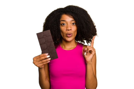 Young African American woman holding a chocolate bar isolated having some great idea, concept of creativity.