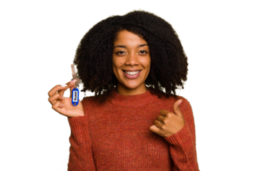 Young African american woman holding home keys isolated smiling and raising thumb up