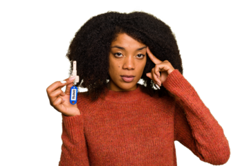 Young African american woman holding home keys isolated pointing temple with finger, thinking, focused on a task.