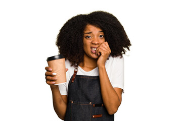 Young african american woman barista holding a takeaway coffee biting fingernails, nervous and very...