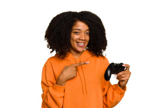 Young African American woman holding a game controller isolated smiling and pointing aside, showing something at blank space.