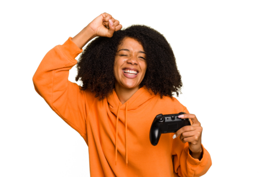 Young African American woman holding a game controller isolated raising fist after a victory, winner concept.