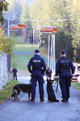 Policjant przewodnik psa podczas pościgu za przestępcą. 