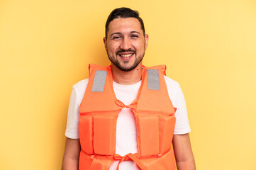 Young latin beach watcher wearing a lifejacket isolated happy, smiling and cheerful.