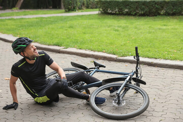 Man with injured knee near bicycle outdoors - Powered by Adobe