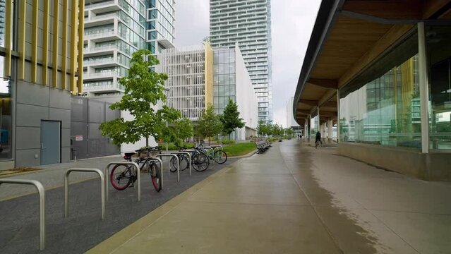 Modern Bus terminal at VMC Vaughan Metropolitan Centre, Ontario, Canada. Exterior walking shot. Person rides a bicycle.