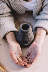 Hands in clay in pottery ceramics workshop